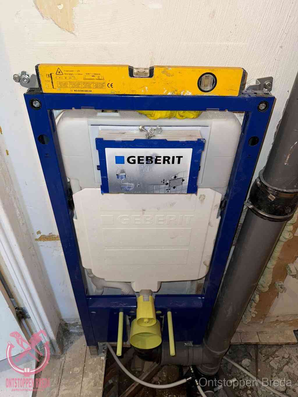 Een Geberit inbouwreservoir met frame voor een hangtoilet tegen de wand, met de afvoerbocht naar de vloer, kenmerkend voor een verstopt hangtoilet in Breda