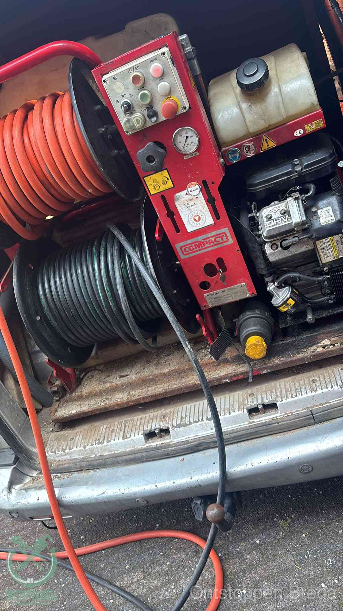 Een rood hogedruk-rioolreinigingstoestel in de laadbak van de bedrijfsbus, apparatuur voor een hardnekkige afvoerverstopping in Breda