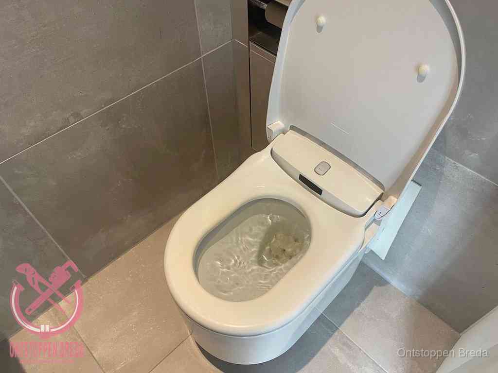 Een toiletpot vol troebel water met drijvend papier en restanten, de meest voorkomende oorzaak van een verstopte wc in Breda