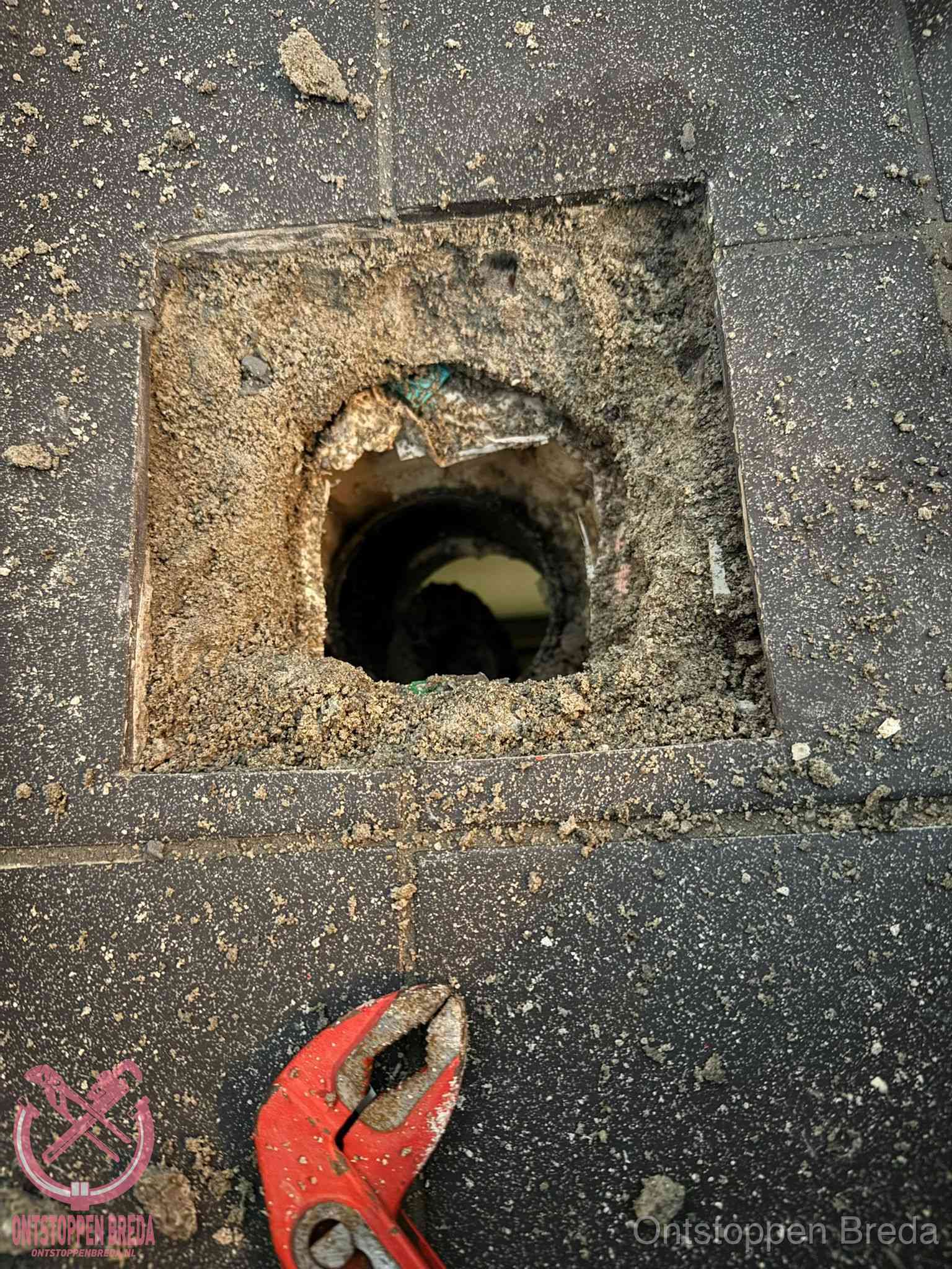 Geopend rioolputje op de erfgrens dat laat zien wie eigenaar is van de riolering in Breda Geopend rioolputje op de erfgrens dat laat zien wie eigenaar is van de riolering in Breda
