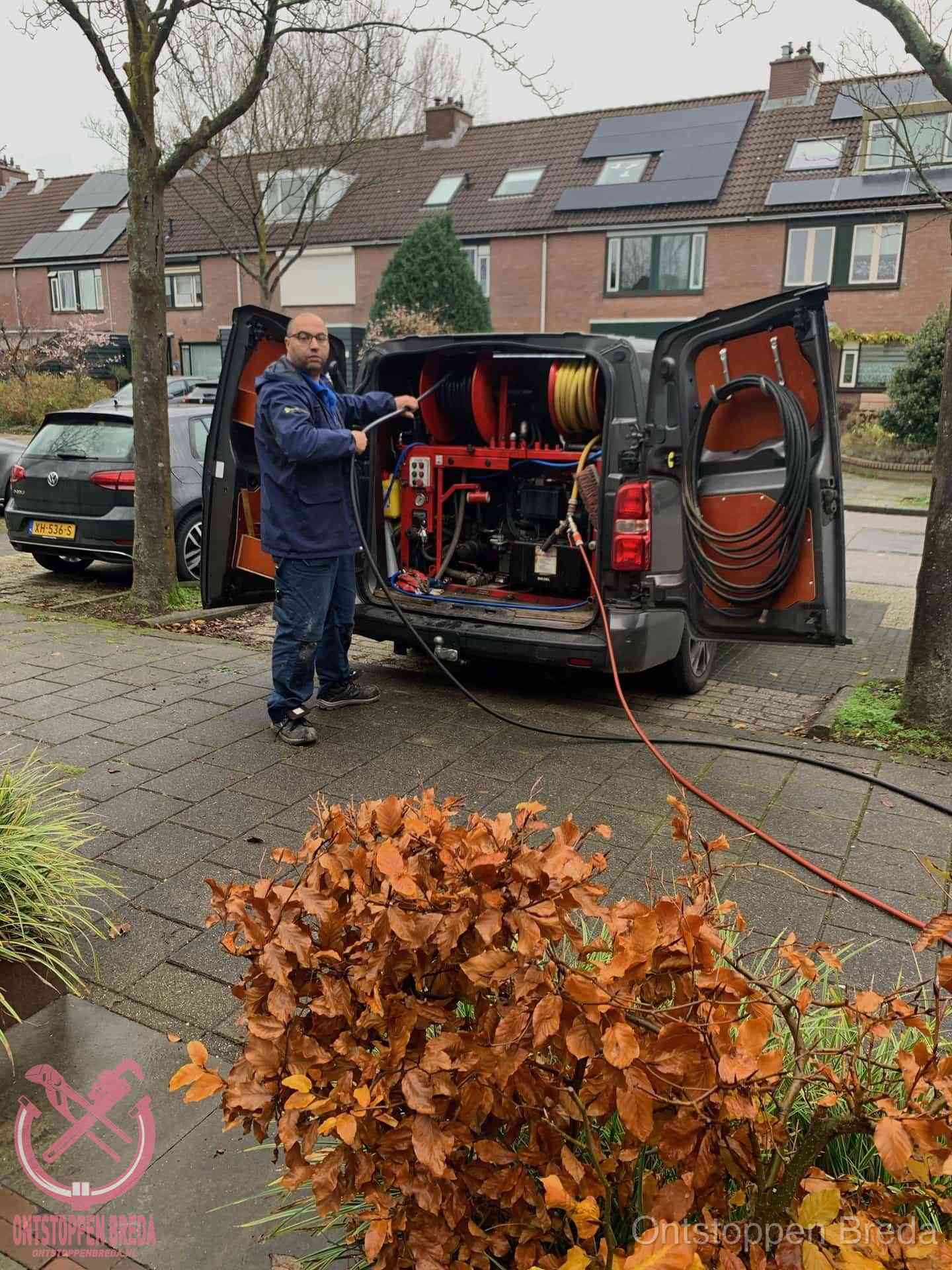 Monteur met rioolreinigingsbus levert rioolservice in de wijk in Breda Monteur met rioolreinigingsbus levert rioolservice in de wijk in Breda